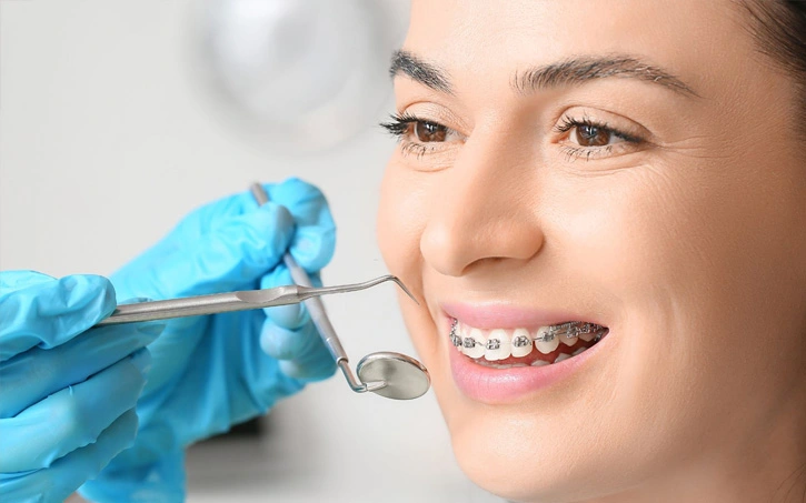 Orthodontist examining a patient's teeth before starting braces or clear aligner treatment in Brooklyn NY