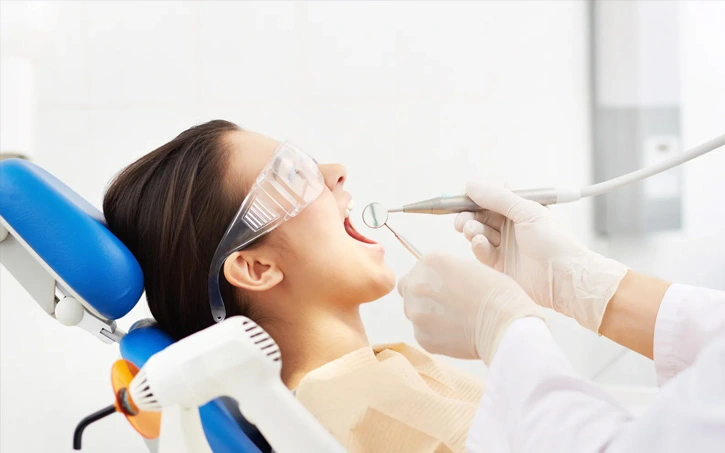Brooklyn cosmetic dentist examining a patient’s smile before a veneer consultation