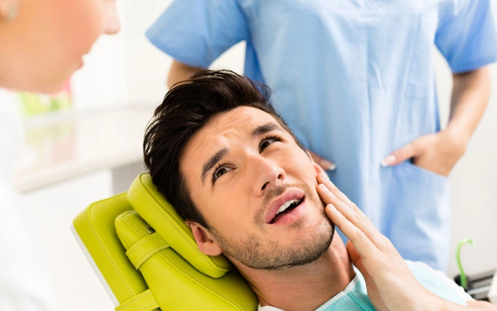 Emergency dentist examining a patient's tooth pain in Brooklyn, NY